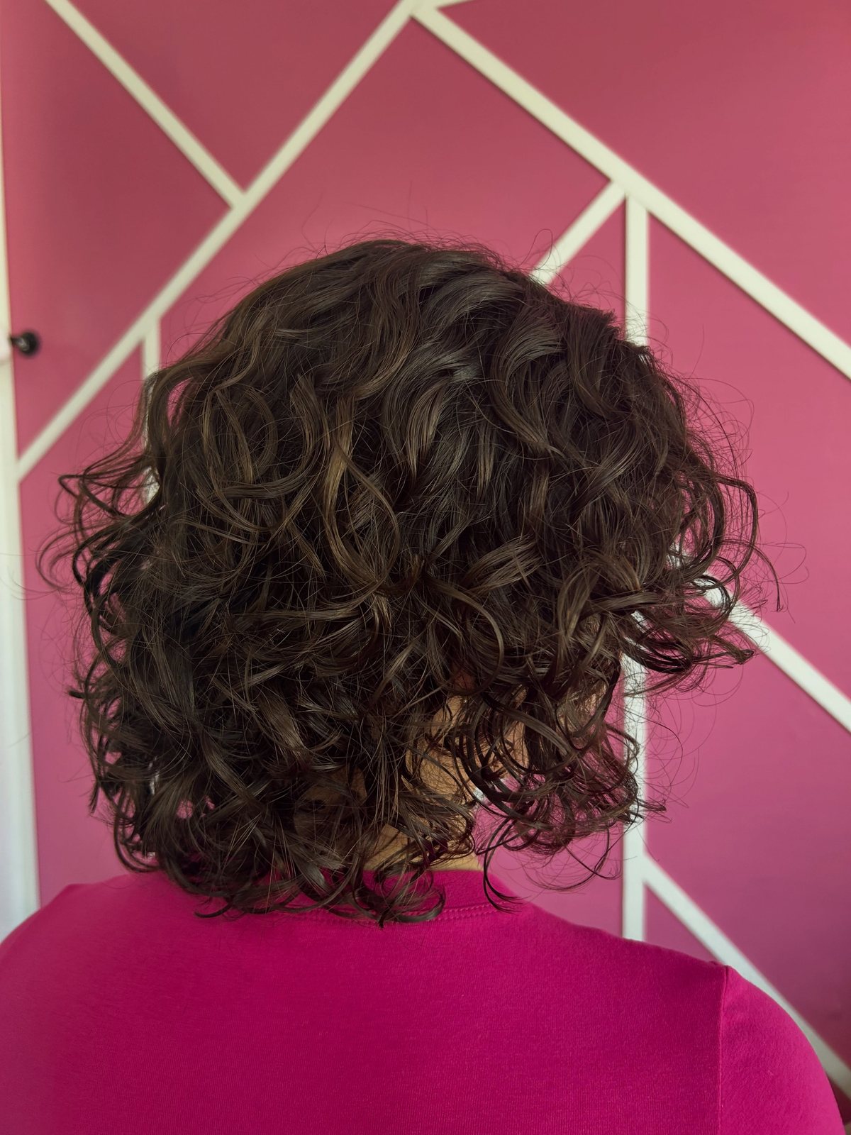 Curly cut: shoulder-length shaped curls, back view